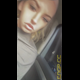 Miss Marilyn sits in a car and pulls her shirt up. No pooping shown. Presented in 720P vertical HD format. About half a minute.